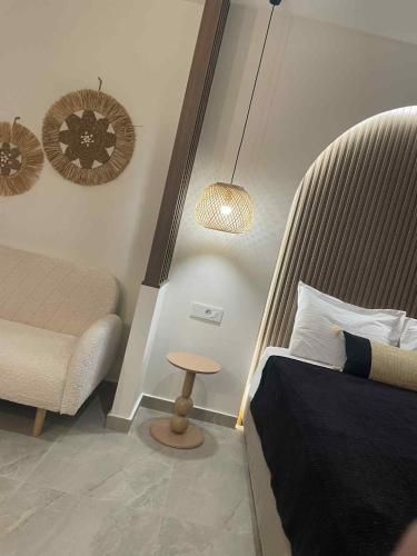 a bedroom with a bed and a chair and a table at Kostas Studios in Faliraki