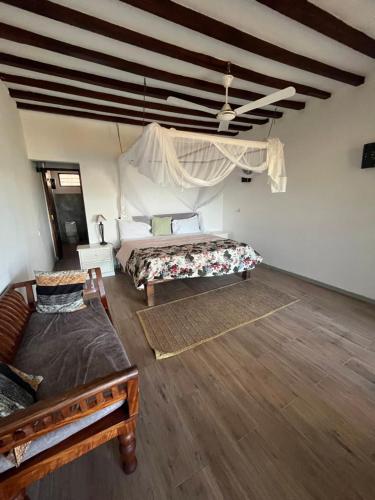 a bedroom with two beds in a room with wooden floors at Malcom Ocean View Retreat in Pongwe