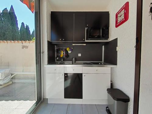 une cuisine avec un évier et un micro-ondes dans l'établissement La Londe Studio avec grande terrasse 4 pers LAL310-001, à La Londe-les-Maures