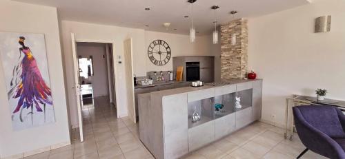 un salon avec un comptoir et une horloge murale dans l'établissement Tout à pied & farniente ! Appartement lumineux avec terrasse, à Sainte-Maxime