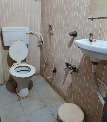 a bathroom with a toilet and a sink at Hotel Shiva in Navi Mumbai