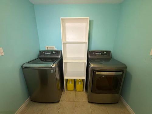 a room with a refrigerator and a washer and dryer at Tranquil Riverside Abode in Cornwall