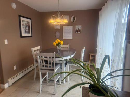 a dining room with a table and chairs and a plant at Tranquil Riverside Abode in Cornwall
