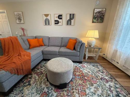 a living room with a blue couch and orange pillows at Tranquil Riverside Abode in Cornwall