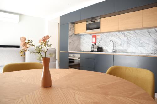 una cocina con una mesa y un jarrón con flores. en RS Porto Central Apartments, en Oporto