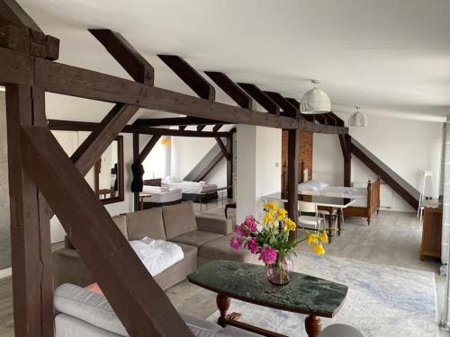 a living room with a couch and a table with flowers at Villa Cuprum in Lubin