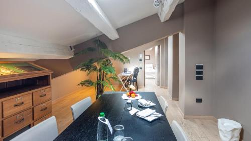 a dining room with a black table and white chairs at I Portici Hotel Bologna in Bologna