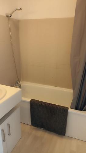 une salle de bain avec un lavabo et une baignoire dans l'établissement Résidence LA CROISIERE, à Anglet