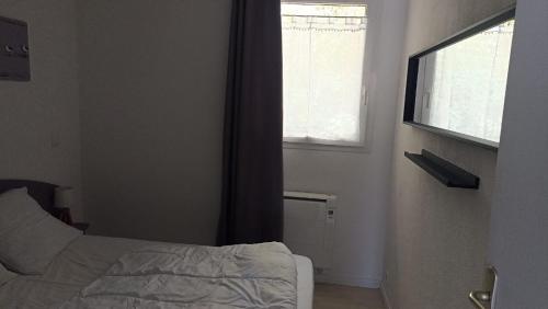 une chambre avec un lit et une fenêtre dans l'établissement Résidence LA CROISIERE, à Anglet