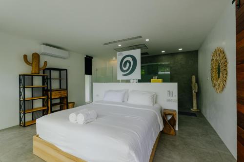 a bedroom with a large bed with white sheets at KPG Suite Dream in Ban Nua