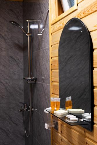 a bathroom with a shower and a mirror at Askrioni - ასკრიონი 