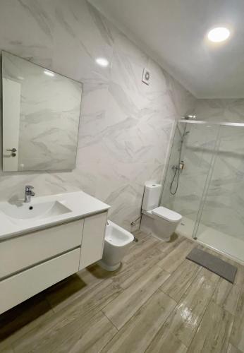 a bathroom with a sink and a toilet and a shower at Oeste Garden Suites in Caldas da Rainha