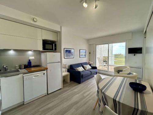 une cuisine et un salon avec une table et un canapé dans l'établissement Appartement avec terrasse, vue sur l'Océan et parking à Royan - FR-1-494-33, à Royan