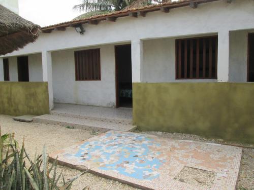 a house with a mosaic floor in front of it at La Femme Noire in Joal-Fadiout