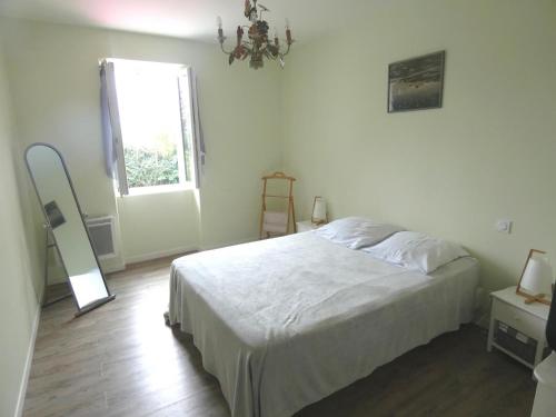 a bedroom with a bed and a window and a chandelier at La dugue sud in Montsoué