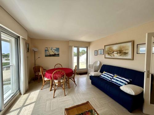 un salon avec un canapé bleu et une table dans l'établissement Spacieux Appartement T3 avec Terrasse Ensoleillée et Parking - FR-1-494-211, à Royan