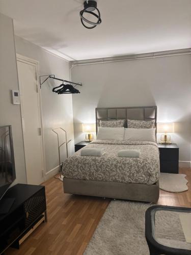 une chambre avec un lit et une télévision dans l'établissement Studio Élégance, à Neuilly-sur-Seine