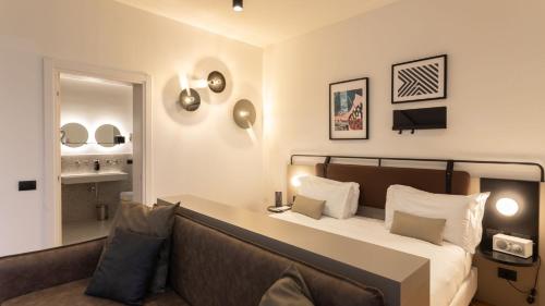 a bedroom with a bed and a couch at I Portici Hotel Bologna in Bologna