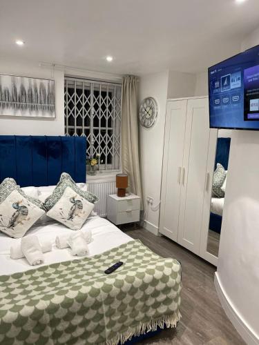a bedroom with a white bed with a blue head board at Two Bedroom Flat C in Kentish Town in London