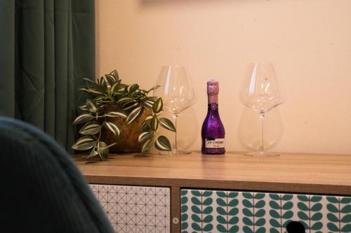 a bottle of wine sitting on a counter with two wine glasses at B&B Mio Nonno Rooms Ljubljana Ex Bizeljčan Rooms in Ljubljana