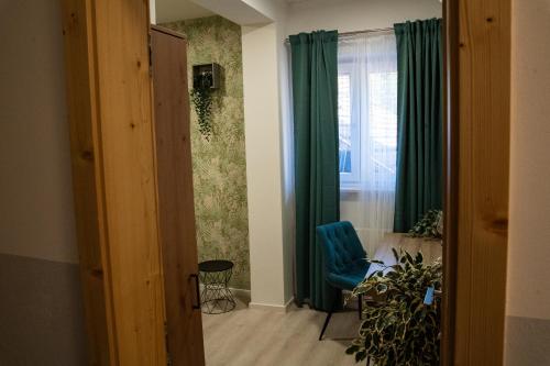a living room with a blue chair and a window at B&B Mio Nonno Rooms Ljubljana Ex Bizeljčan Rooms in Ljubljana