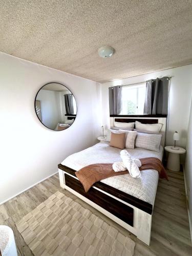 a bedroom with a large bed with a mirror at Jayla's By The Marina in Batemans Bay
