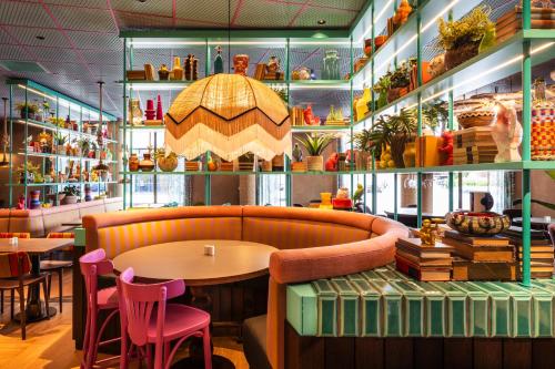 a restaurant with a table and chairs and shelves with vases at Quality Hotel The Reef in Frederikshavn