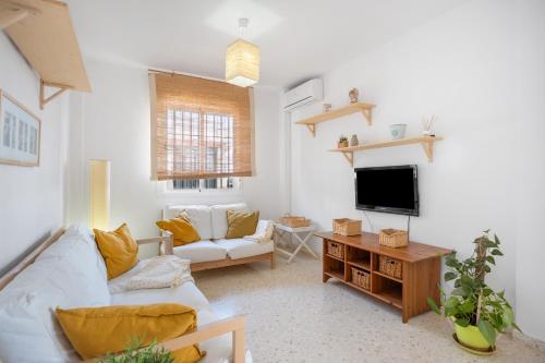 a living room with a couch and a tv at Camaleón 7 in Chipiona