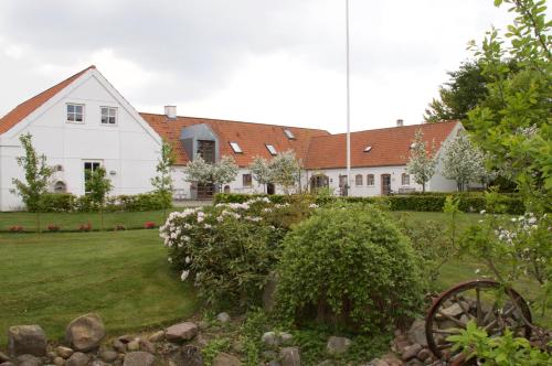 ein weißes Haus mit einem Garten davor in der Unterkunft LILLEVANG APARTMENTs in Billund