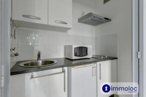 une petite cuisine avec un évier et un micro-ondes dans l'établissement Air-conditioned studio near the Promenade des Anglais, à Nice