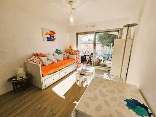 - un salon avec un canapé orange et une fenêtre dans l'établissement Studio avec terrasse à proximité des plages, Wi-Fi, à Saint-Elme