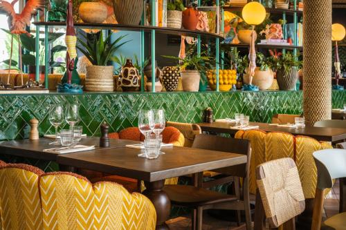 a restaurant with tables and chairs and plants at Quality Hotel The Reef in Frederikshavn