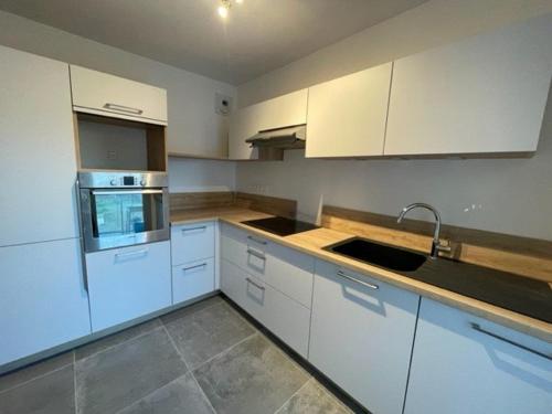 une cuisine avec des armoires blanches et un évier dans l'établissement Quiberon - Grand T2 - Balcon Sud - 70m² - Plage & Centre - Parking & WIFI - FR-1-478-203, à Quiberon