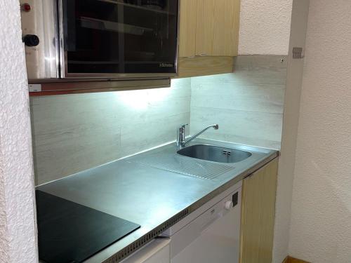 un comptoir de cuisine avec un évier et un micro-ondes dans l'établissement Studio lumineux avec balcon, proche des pistes - FR-1-181-2645, à La Plagne Tarentaise