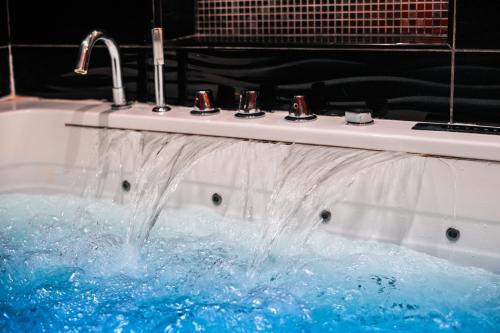 a sink with water coming out of it at Le Cabaret Vip SPA in Lyon