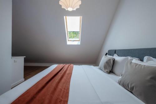 a white bed in a room with a window at Artifact Apart Hotel in Tbilisi City