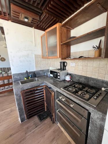 a kitchen with a stove and a sink at Malcom Ocean View Retreat in Pongwe