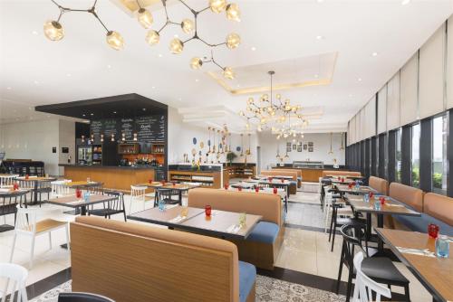a restaurant with tables and chairs and a bar at Park Inn by Radisson North Edsa in Manila
