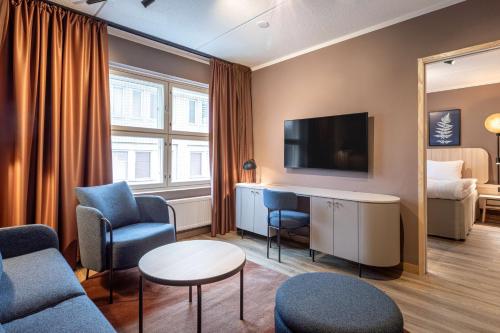 a hotel room with a couch and a tv at Scandic Lahti City in Lahti