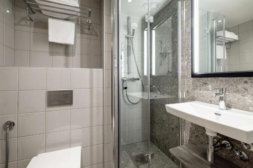 a bathroom with a sink and a shower at Scandic Lahti City in Lahti