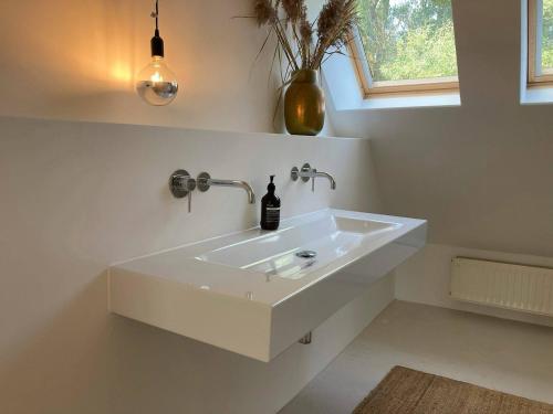 a white bathroom with a sink and a window at NONNA Hof - Natur & Ruhe in Ostseenähe in Altwigshagen