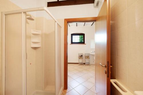 Baño con ducha a ras de suelo junto a una puerta en Mono Garden Colombare Teboi, en Lazise