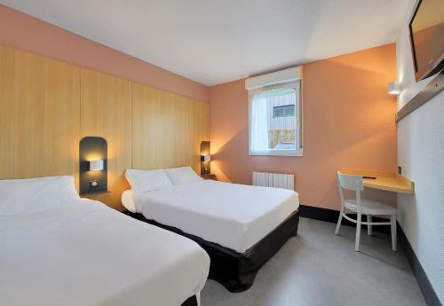 a hotel room with two beds and a desk at B&B HOTEL Le Tréport Friville in Friville-Escarbotin