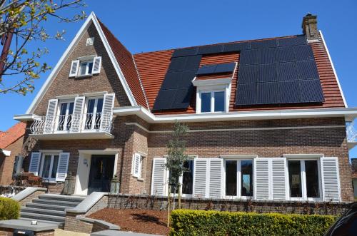 a house with solar panels on the roof at B&B Amylia in Wenduine