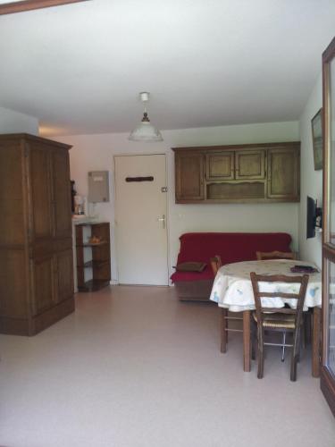 un salon avec une table et un canapé dans l'établissement apt t2 100 m de la plage et a l oree de la foret, à Saint-Georges-de-Didonne