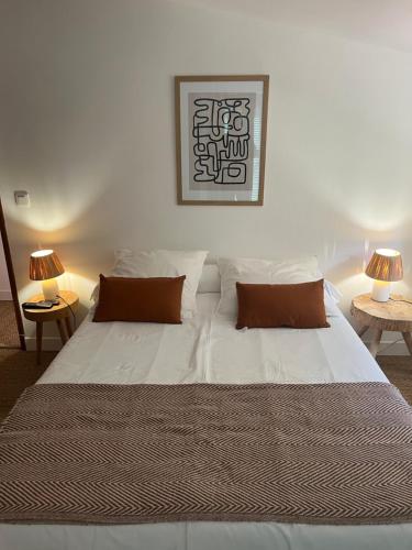 une chambre avec un grand lit blanc avec deux lampes dans l'établissement Casa Dume, à Calenzana