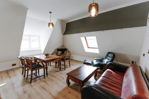 a living room with a couch and a table and chairs at Ferienwohnungen am Holstentor in Lübeck