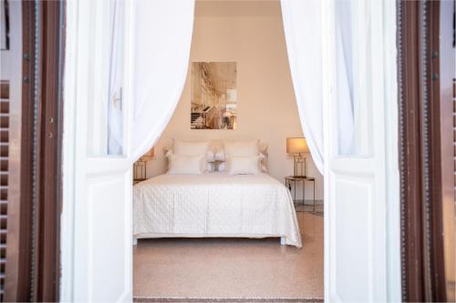 a bedroom with a white bed with white curtains at La Corte di Partenope Luxury Suite in Naples
