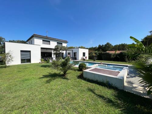 une maison avec une piscine dans une cour dans l'établissement Villa de luxe tout confort, à Bénesse-Maremne