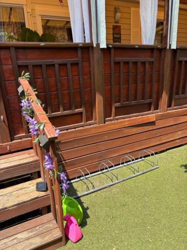 a wooden bench with flowers on the side of a house at Myosotis mobile home 6p camping siblu in Fréjus